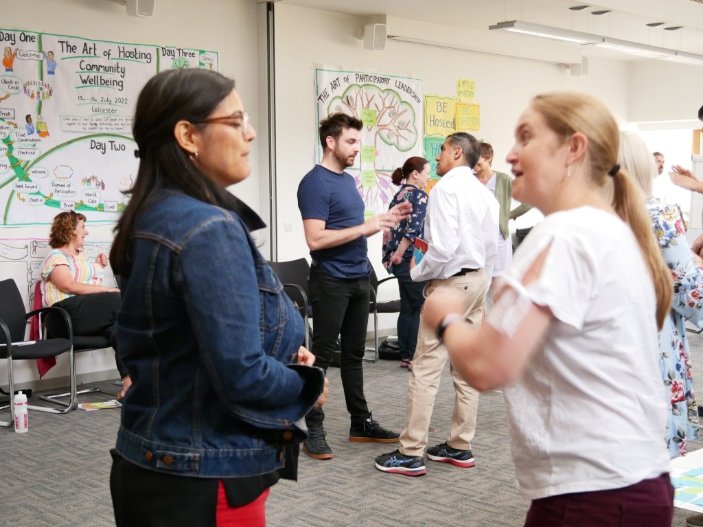 Photo of Sarah Marsay in group event talking to a participant.